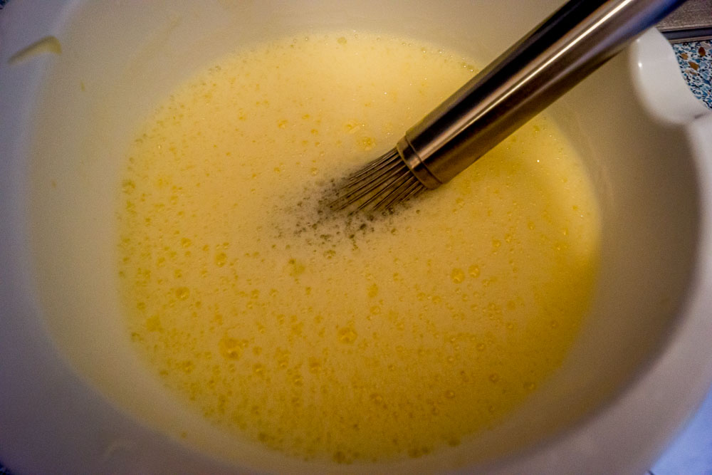 Beim Einrühren der Milch bildet sich viel Schaum auf der Milch-Ei-Masse